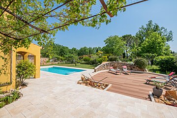 A yellow house with a swimming pool in the backyard