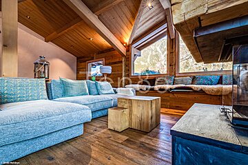 A living room with a blue couch and a wooden table