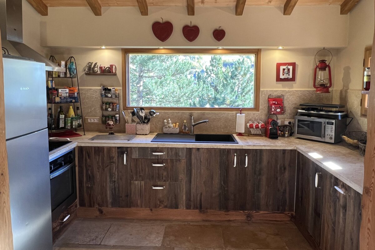 A kitchen with wooden cabinets and a stainless steel refrigerator