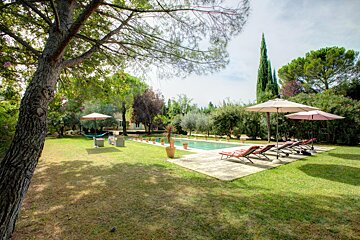 A large swimming pool surrounded by chairs and umbrellas