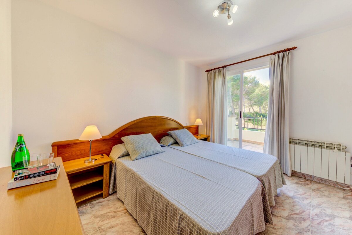 A bedroom with two beds and a bottle of sprite on the nightstand