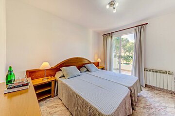 A bedroom with two beds and a bottle of sprite on the nightstand