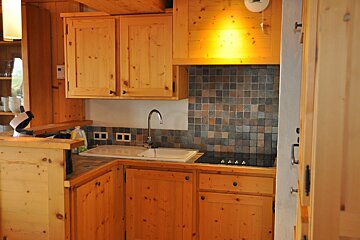 A kitchen with wooden cabinets and a stove top oven