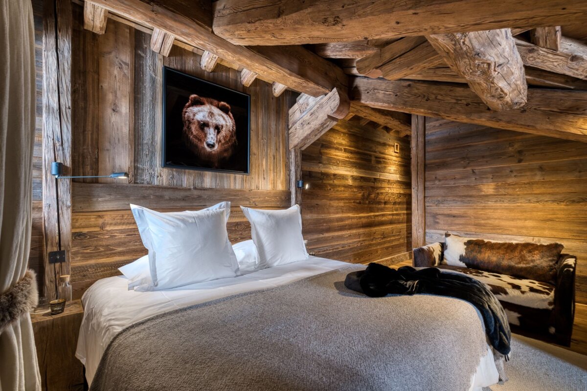 A bedroom with a picture of a bear on the wall above the bed
