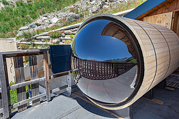 A wooden barrel with a mirror on top of it