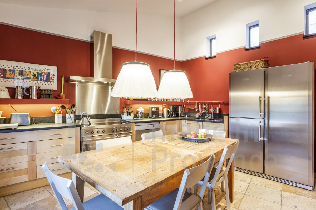A kitchen with red walls and stainless steel appliances