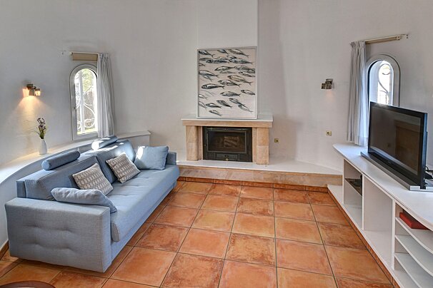 A living room with a blue couch and a fireplace