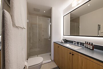 A bathroom with a toilet a sink and a mirror