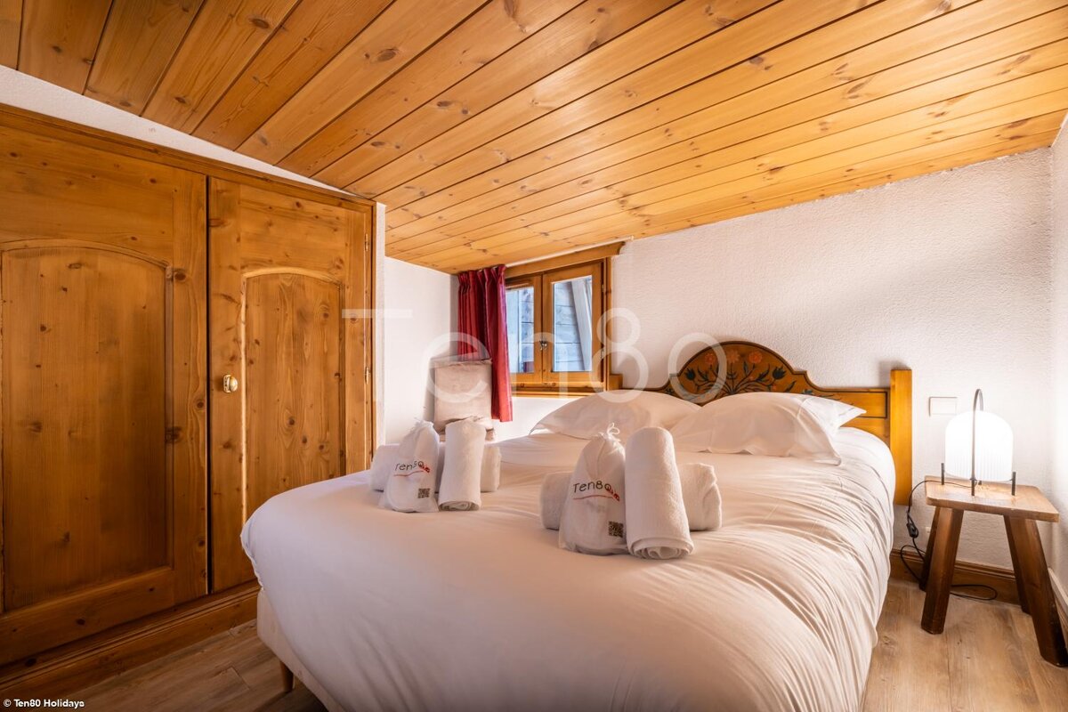 A bedroom with a bed and towels that say terra on them