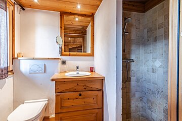 A bathroom with a toilet a sink and a mirror