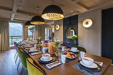 A long dining table with plates and bowls on it