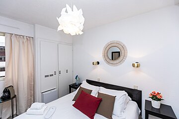 A bedroom with a bed and a mirror on the wall