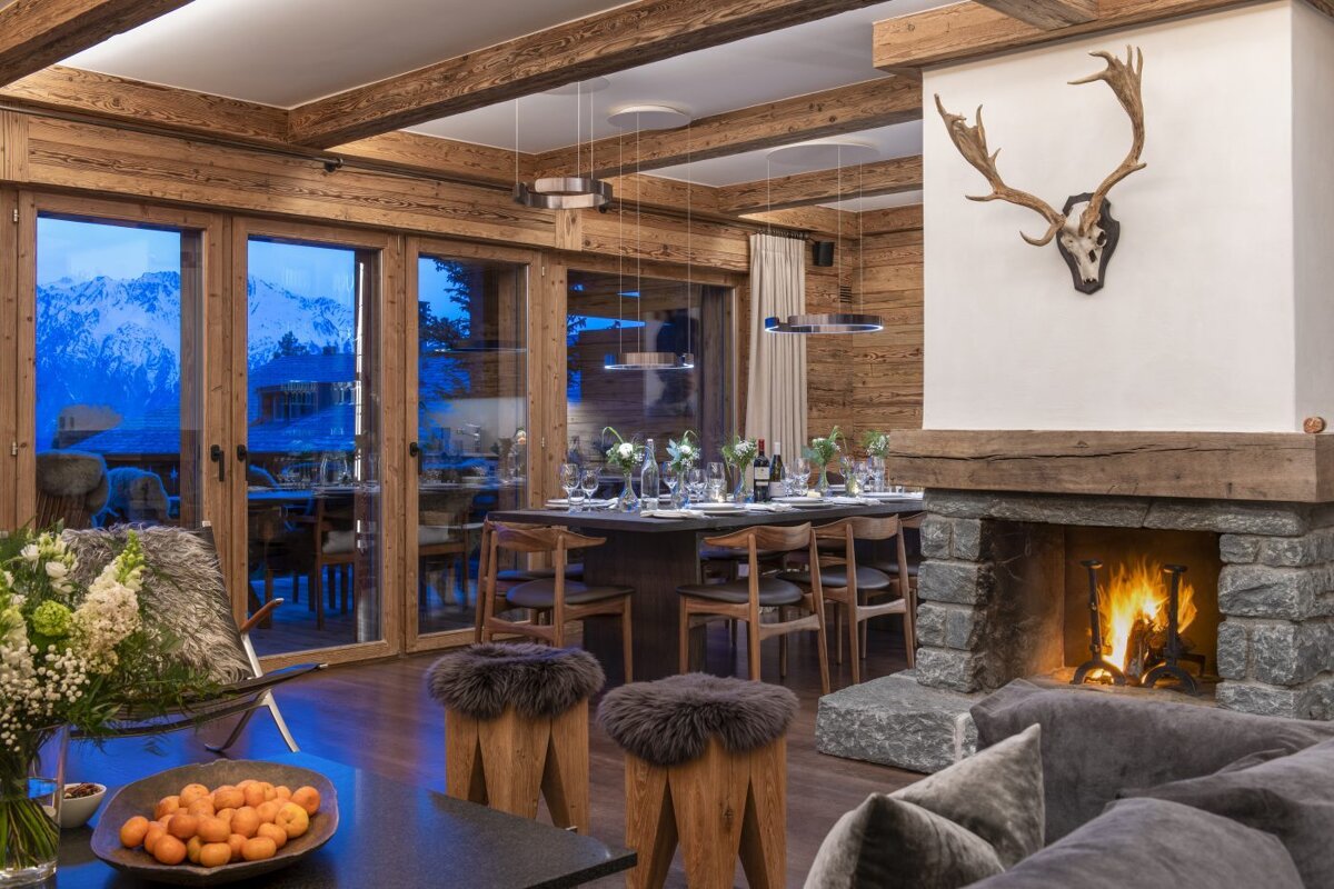 A dining room with a table and chairs and a fireplace