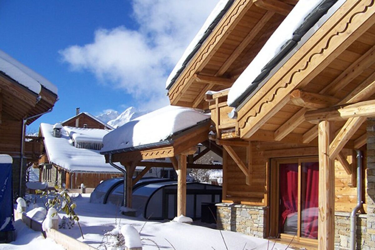 A wooden building with snow on the roof