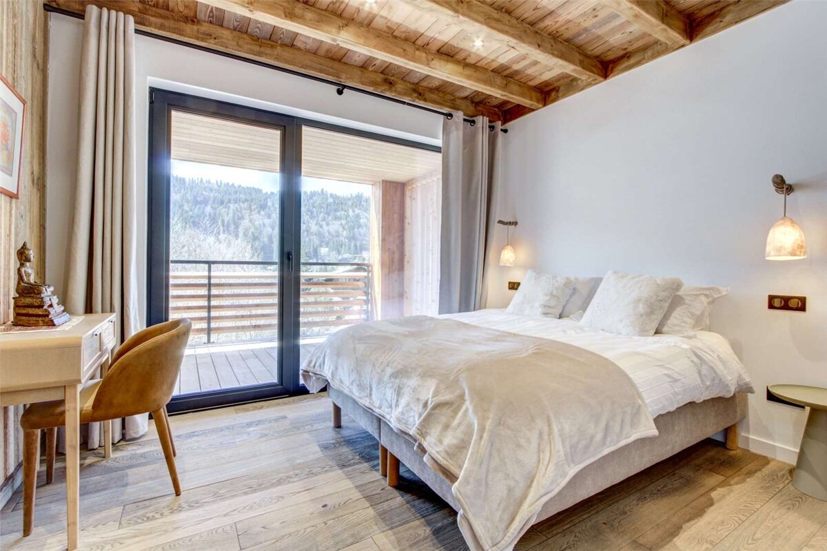 A bedroom with a large bed and a sliding glass door