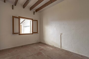 An empty room with a window and wooden beams