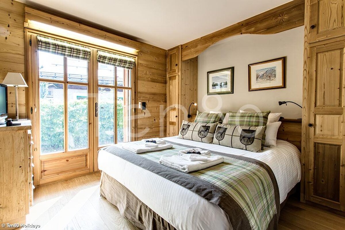 A bedroom with a large bed and a picture on the wall that says holidays