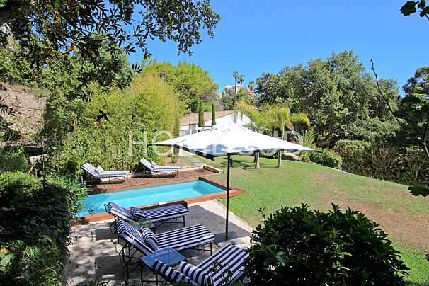 A swimming pool surrounded by lawn chairs and umbrellas with the word home on the bottom