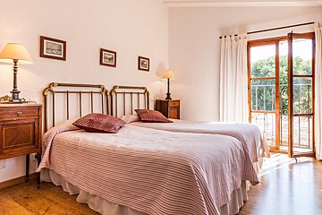A bedroom with two beds and two lamps