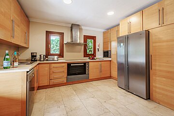 A kitchen with wooden cabinets and a stainless steel refrigerator
