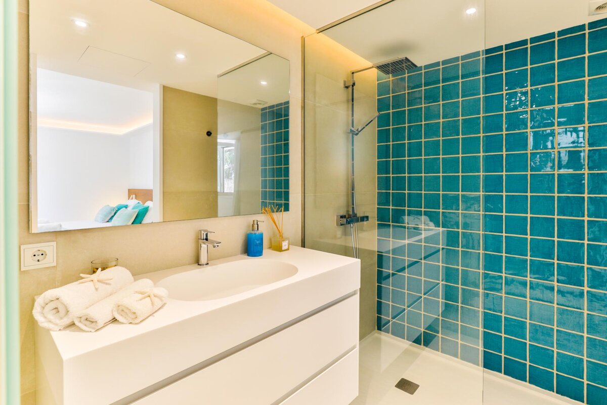 A bathroom with blue tiles and a walk in shower