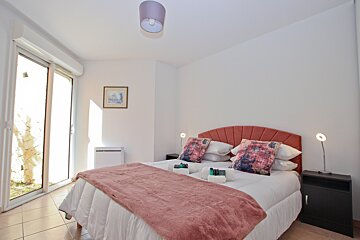 A bedroom with a bed and a picture on the wall