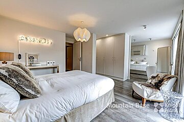 A bedroom with a bed a chair and a sign that says snowy