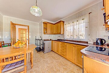 A kitchen with a bowl of oranges on the counter