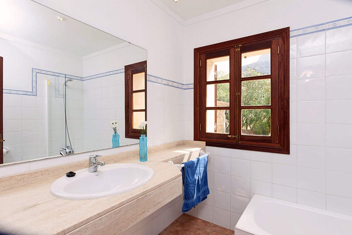 A bathroom with a sink a mirror and a window