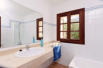 A bathroom with a sink a mirror and a window