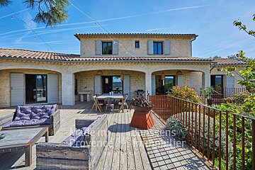 A large stone house with a wooden deck in front of it