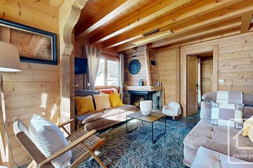 A living room with a couch and a fireplace and a sign that says alpine-pro