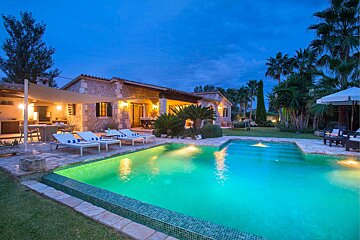 A house with a large swimming pool in front of it