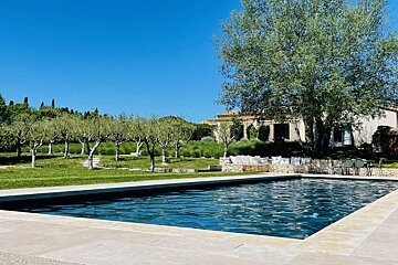 A large swimming pool with a house in the background