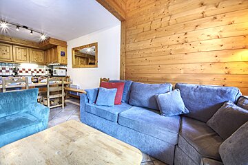 A living room with a blue couch and a wooden table