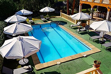 A large swimming pool surrounded by chairs and umbrellas