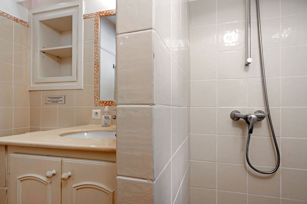 A bathroom with a sign on the wall that says 