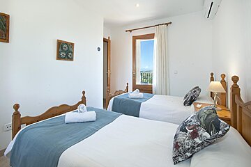 A bedroom with two twin beds and a window