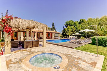 A large swimming pool with a hot tub in front of it
