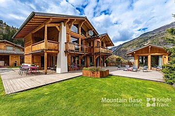 A large wooden house is for sale by mountain base