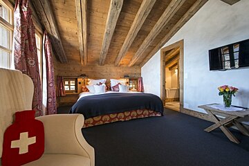 A chair with a red cross on it sits next to a bed