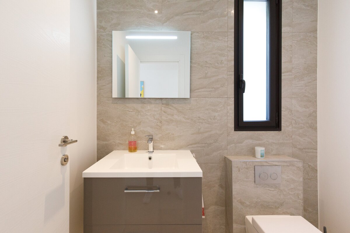 A bathroom with a sink a toilet and a mirror