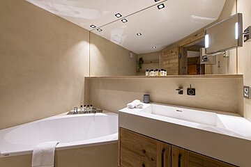 A bathroom with a bathtub and a sink and a mirror