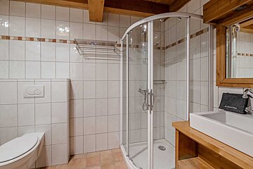 A bedroom with a wooden ceiling and a bed