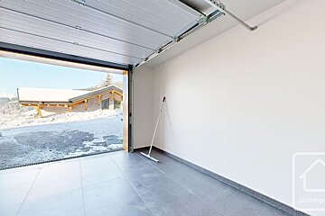An empty garage with the word alpine on the bottom right