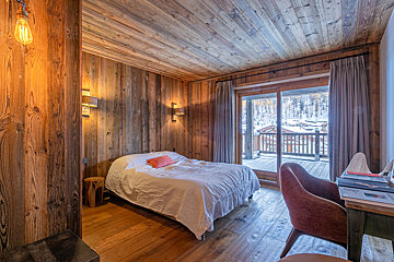 A bathroom with wooden walls and two sinks
