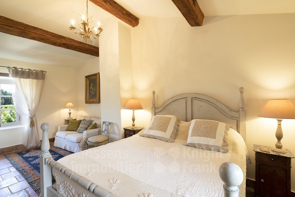 A bedroom with a bed and a chair with the word knight on the bottom