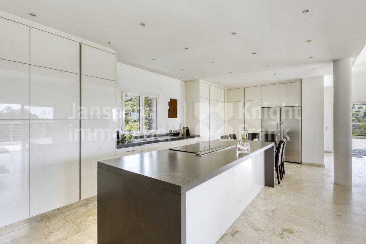 A kitchen with white cabinets and a large island with the word knight on it