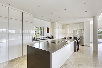 A kitchen with white cabinets and a large island with the word knight on it