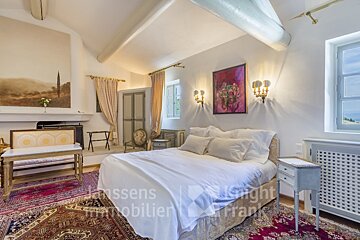 A bedroom with a bed and a painting on the wall that says knight immobilier